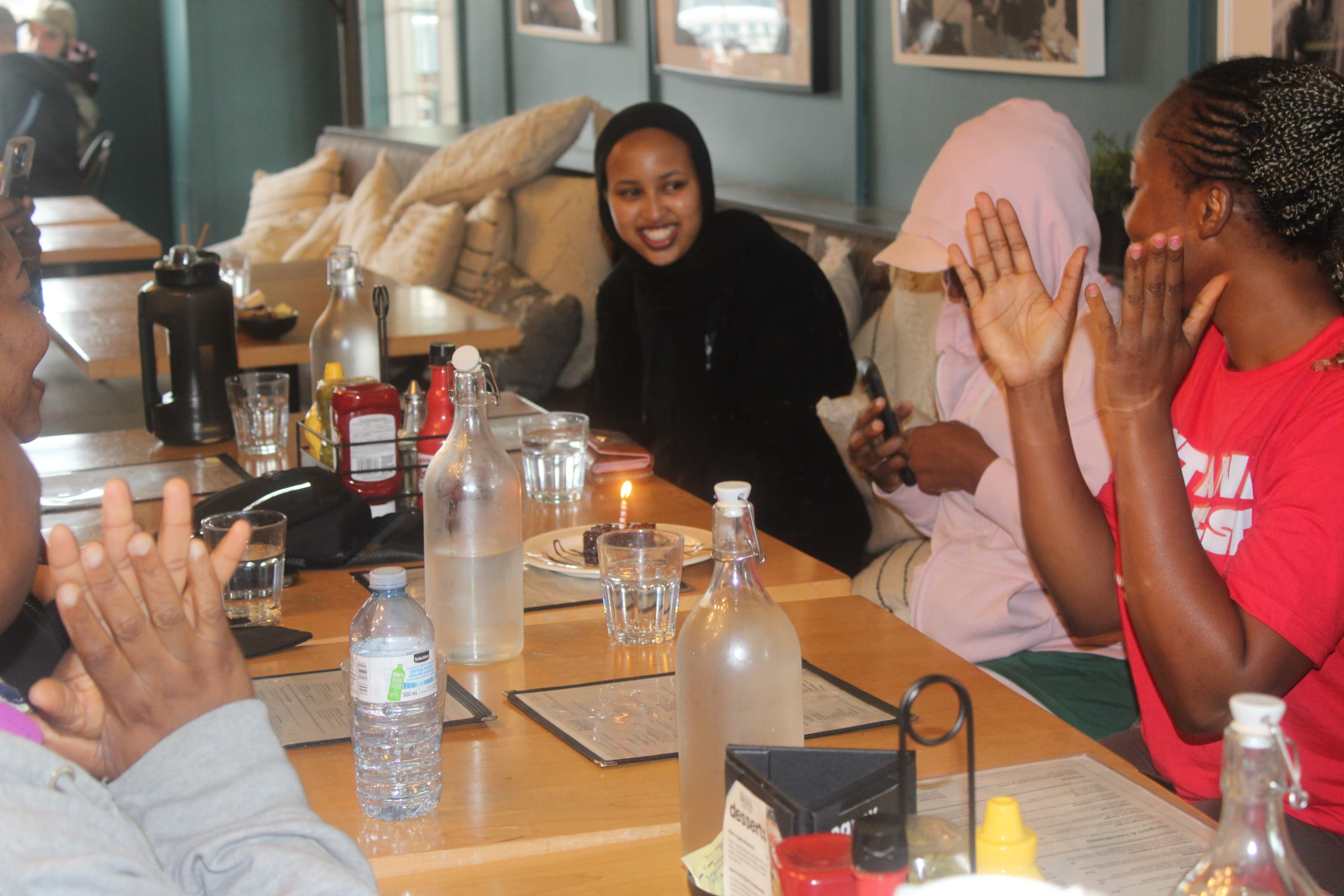 Members laughing around a cafe table at a Coffee and Connection meetup