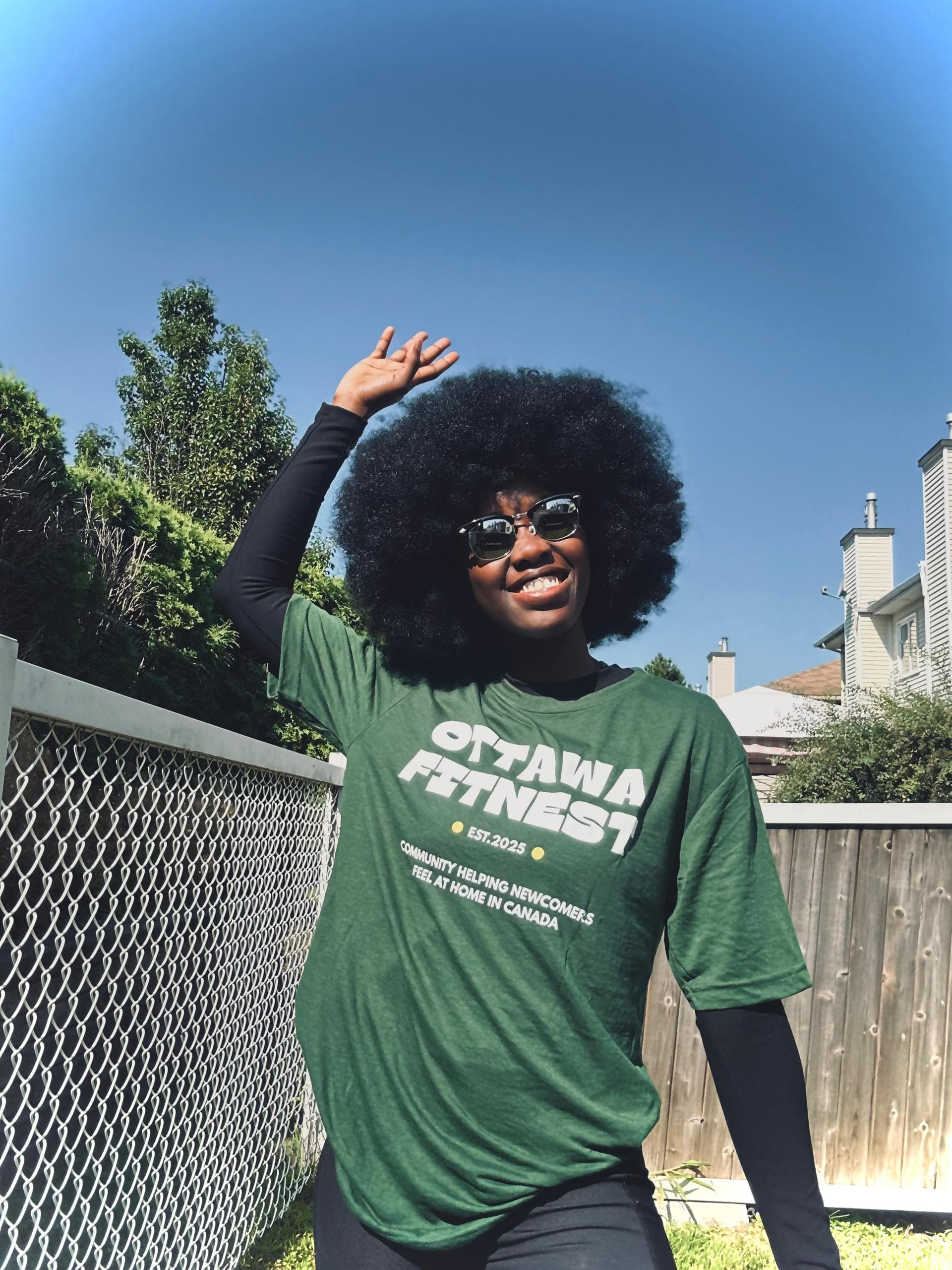 A member in an Ottawa Fitnest shirt reading "helping newcomers feel at home in Canada"