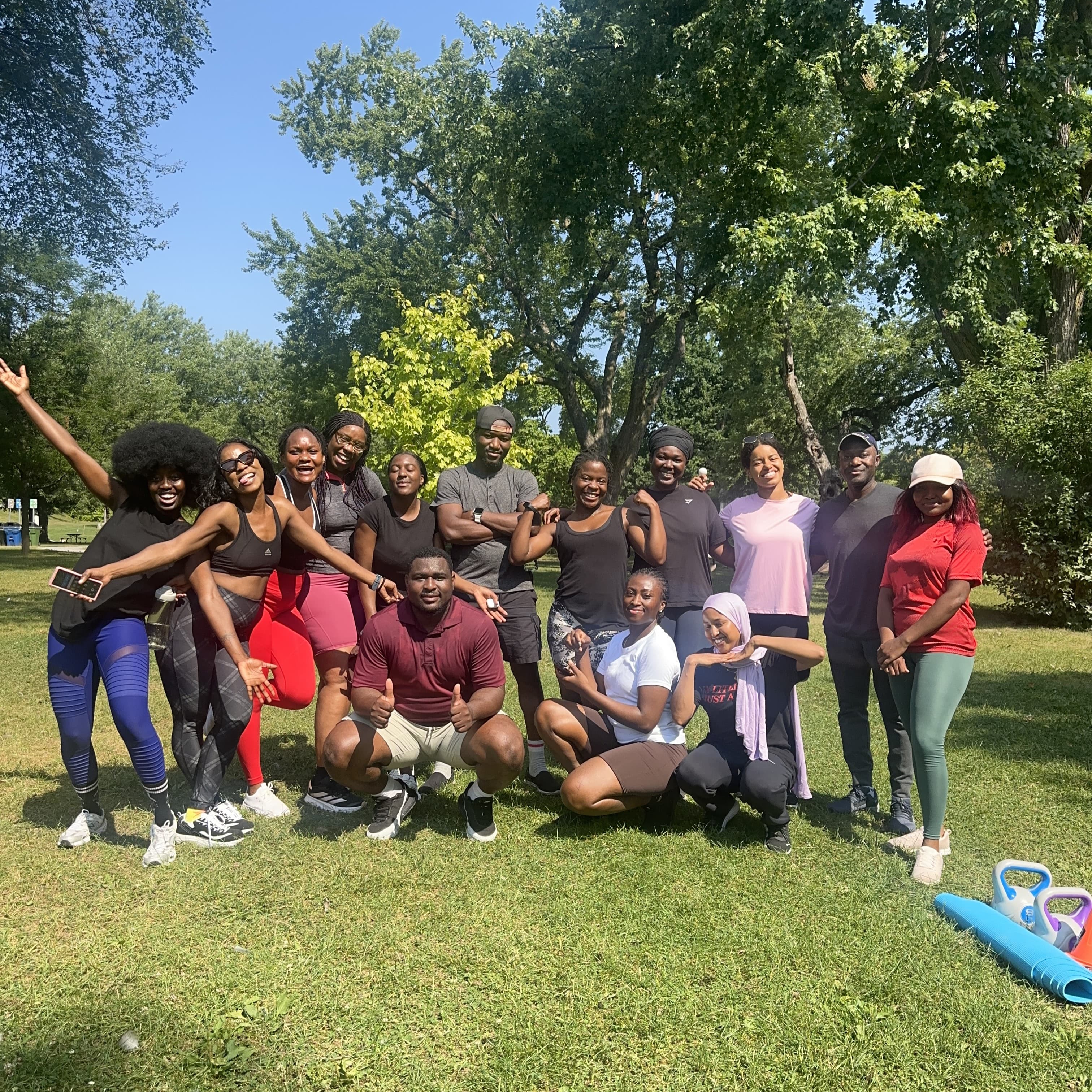 The group posing together on the grass after a park workout